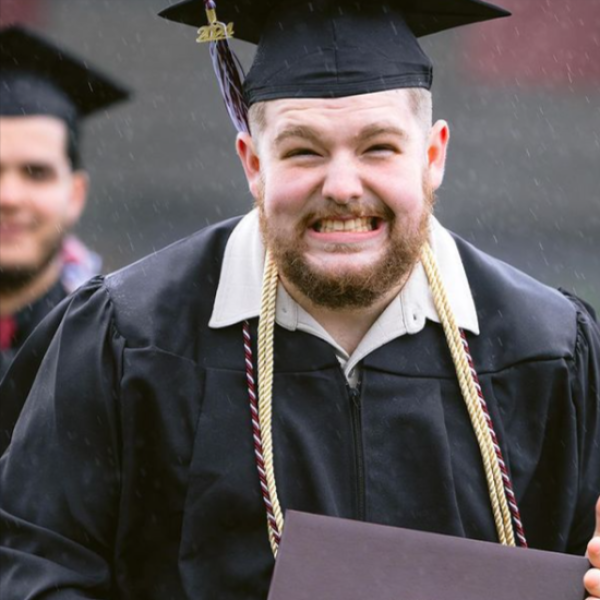 A very happy graduate in the rain during Commencement 2024